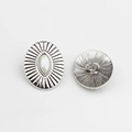 Detail of vintage silver oval alloy button with sunburst pattern and white resin inlay - White