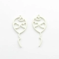Macro view of matte white hollow balloon pendants with heart cutouts for jewelry making - White