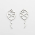 Macro shot of silver hollow balloon charms with heart patterns for DIY jewelry making - Silver