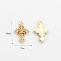 Detaillierte Makroansicht von 18mm Gold-Kreuzanhängern mit weißen Strasssteinen beidseitig - Strass Sarg Kreuz Stil