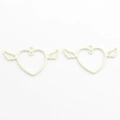 Macro shot of cream-colored winged heart alloy charms for DIY jewelry making - White