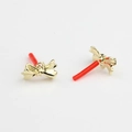 Close-up of golden bow-shaped stud earrings with red protective needle caps - Gold