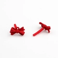 Macro shot of red matte resin bow-shaped stud earrings on a clean white background - Red