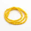 Dettaglio di perline di vetro giallo brillante a forma di osso per gioielli fai-da-te - Giallo
