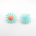 Vue détaillée avant et arrière de boucles d'oreilles marguerites bleues en résine - Bleu