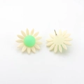 Détails macro des boucles d'oreilles marguerites en résine avec centre vert - Abricot