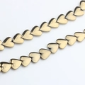 Macro shot of 10mm golden heart-shaped hematite beads with high metallic luster for DIY - Gold