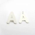 Detail view showing white acrylic letter A stud earrings with front and back pin structure - Letter Stud Earrings / White