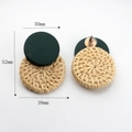 Detail view of emerald green resin and woven rattan geometric earrings with size markers - Green
