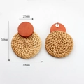 Detailed view of handmade woven rattan drop earrings with orange wood top and metal posts - Orange