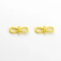 Détails macro de pendentifs nœuds jaune mat avec deux boucles pour la création de bijoux - Jaune