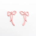 Détail macro de pendentifs nœuds en métal laqué rose mat pour bijoux DIY - Rose