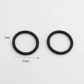 Close-up detail of two black 2mm thick O-ring rubber seals with 25mm diameter measurements - Round