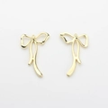 Close-up of golden bow-shaped metal pendants with polished mirror finish for DIY jewelry - Gold