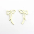 Close-up of cream white bow pendants with metal alloy texture for DIY jewelry making - Off White