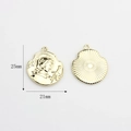 Detail of vintage gold alloy Joan of Arc coin charm with embossed relief and sunburst texture - Joan of Arc Portrait with Sword (01)