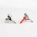Detail of silver liquid metal heart earrings with mirror finish and red protective caps - Silver