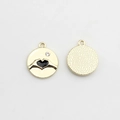 Detail view of round gold pendants with black enamel heart gesture and crystal inlay - Gold