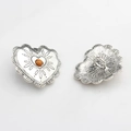 Detailed view of vintage silver heart alloy button with brown bead and wavy lace edges - Orange