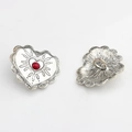 Macro view of vintage heart-shaped alloy buttons with red stone and embossed patterns - Rose Red