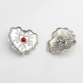 Detail of vintage heart-shaped alloy buttons with red center and antique silver lace edges - Rhodochrosite