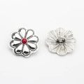 Close-up of vintage flower alloy button with red stone inlay and antique silver finish - Rose Red