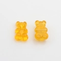 Macro detail of cute yellow candy-colored resin bear charms for DIY jewelry making - Orange
