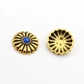Detailed view of vintage gold daisy alloy pendant with a bright blue center gemstone - Sapphire Blue