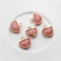 Macro detail of five pink quartz fan-shaped pendants with golden faceted edges - Pink