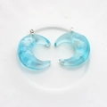 Detailed view of crescent moon resin pendants with blue sky and white cloud design - Moon