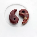 Polished natural red jasper teardrop pendants with yellow veining in a ceramic bowl - Rainbow Stone