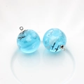 Macro detail of blue resin ball pendants with white clouds and flying bird silhouettes - Ball