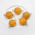 Detailed view of five orange natural stone jewelry connectors with gold plating edges - Yellow