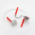 Close-up of textured round silver earring posts for DIY jewelry making in ceramic tray - Silver