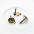 Close-up of vintage alloy earring posts with textured surface for DIY jewelry making - Antique Gold