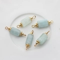 Detailed close-up of 5 light blue stone cylinder charms with golden metal loops - 22*6mm-24*7mm / Aquamarine