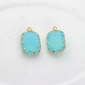 Macro shot of sky blue faceted glass pendants with gold flower claw settings for DIY - Blue