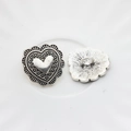 Macro shot of antique silver heart-shaped alloy buttons with ornate textured relief - Large / Silver