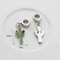Detail view of mini green enamel cactus charms with red rhinestones for DIY jewelry - Cactus