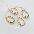 Macro view of four 14K gold-plated teardrop pendants with faceted glass for DIY jewelry - Clear White