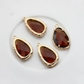 Close-up of four brown faceted glass teardrop pendants with 14K gold-filled metal frames - Brown