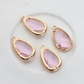 Detailed view of four 14K gold-plated pink faceted glass teardrop pendants on white surface - Light Pink