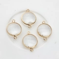 Macro view of four 16mm round faceted crystal pendants with gold plated metal rims - White