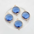 Macro view of four 16mm round blue faceted crystal pendants with gold plated frames - Medium Blue