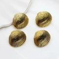 Set of four vintage gold scallop shell alloy charms with detailed radial texture on white - Antique Gold