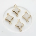 Macro view of gold-plated clover connectors with white resin for jewelry making - White Jade
