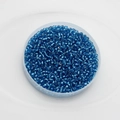 Macro shot of vibrant blue 2mm glass seed beads for DIY jewelry making in a round container - Pack Of 10g / Lake Blue