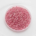 Macro shot of 2mm silver-lined pink glass seed beads in a round storage case for DIY jewelry - Pack Of 10g / Pink