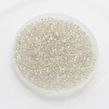 Close-up of 2mm silver-lined glass seed beads in a transparent round container tray - Pack Of 10g / Clear White