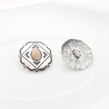 Macro detail of vintage silver alloy buttons with pink resin gemstone and floral lace edge - Apricot